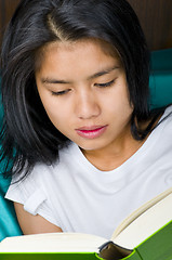 Image showing woman reading a book in bed