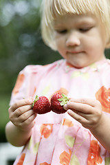 Image showing Girl holding two strawberries.