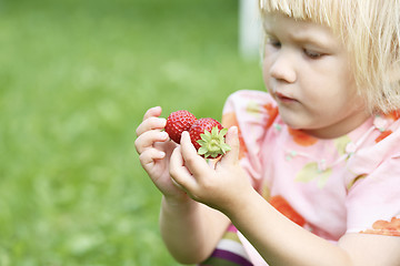 Image showing Girl holding two strawberries.