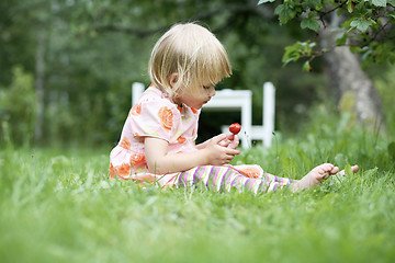 Image showing Girl holding a strawberry.