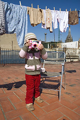 Image showing sweet girl with pink digital camera and clothesline