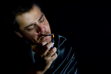 Image showing man is lighting a cigarette