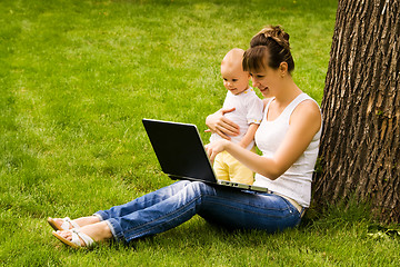 Image showing Happy family with notebook on the grass