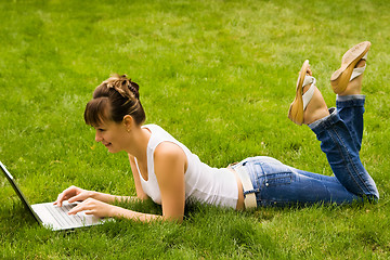 Image showing Happy young woman with notebook on the grass