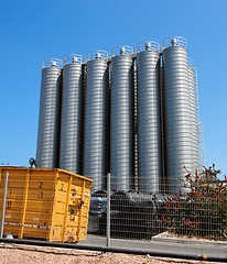 Image showing Twelve high metal tower silos on chemical plant