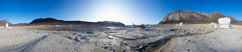 Image showing Icebergs and red helicopter in the middle of a dried out lake