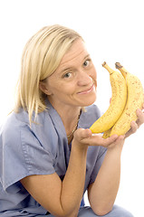 Image showing smiling happy nurse doctor with healthy fresh bunch ripe bananas
