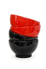 Image showing Zigzag stack of two red and two black porcelain bowls isolated