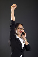 Image showing attractive businesswoman on the phone winning over black background