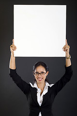 Image showing  attractive businesswoman holding a blank board over her head