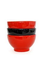 Image showing Stack of two red and one black porcelain bowls isolated