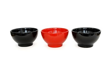 Image showing Row of two black and one red porcelain bowls isolated