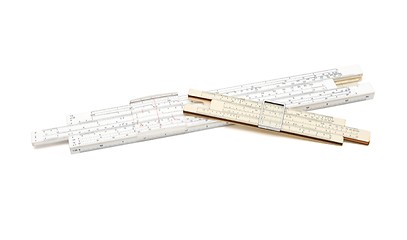 Image showing Two crossed vintage slide rule mechanical calculators isolated