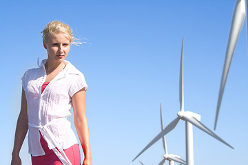 Image showing young woman dreams about the future on a wind farm beneath eolic