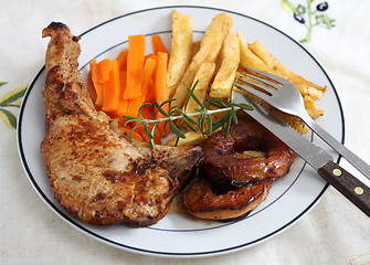 Image showing Pork chop with apple, carrots and chips