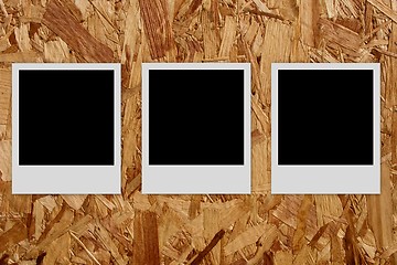 Image showing Three empty photo frames  on wood background