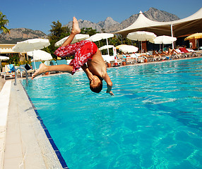 Image showing Boy jumping into swimming pool