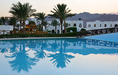 Image showing Palms reflection in pool at tropical sunset