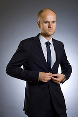 Image showing businessman buttoning his coat