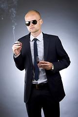 Image showing young businessman drinking and smoking