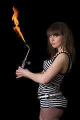 Image showing Pretty young woman with a gas torch. Isolated