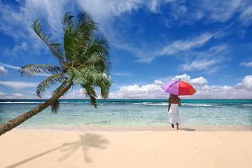 Image showing Tropical Location With Palm Tree and Woman Holding Umbrella