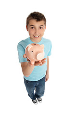 Image showing Smiling boy holding a pink pig money box