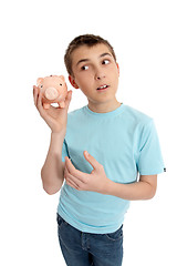 Image showing Pre teen boy rattling a money box