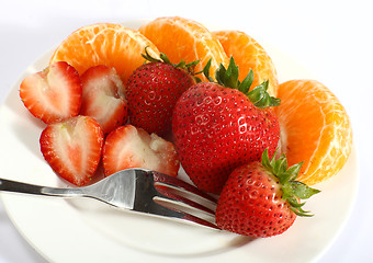 Image showing Strawberries and tangerines with fork