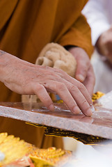 Image showing Hand of Buddhist monk painting religious symbols