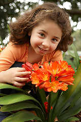 Image showing Little girl in a garden of clivia miniata