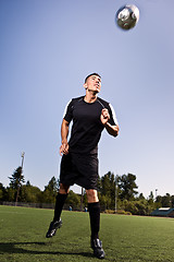 Image showing Hispanic soccer or football player heading a ball