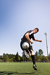 Image showing Hispanic soccer or football player kicking a ball