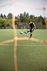 Image showing Hispanic soccer or football player kicking a ball
