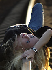 Image showing Young woman lying on rail