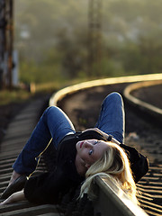 Image showing Young woman lying on rail