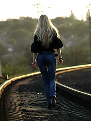 Image showing Young woman walking by railway