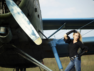 Image showing Young woman near vintage airplane