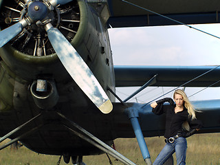 Image showing Young woman near vintage airplane