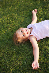 Image showing Happy girl relaxing on a grass