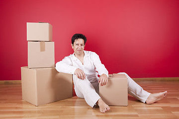 Image showing Young men resting next to cardboard boxes