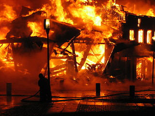 Image showing Firefighter fighting burning hous
