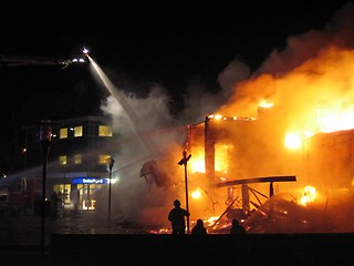 Image showing Firefighter fighting burning house