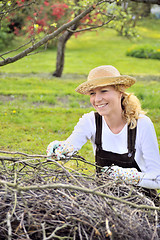 Image showing Young woman cleaning tree limbs