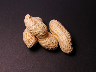 Image showing  3 peanuts over the black background