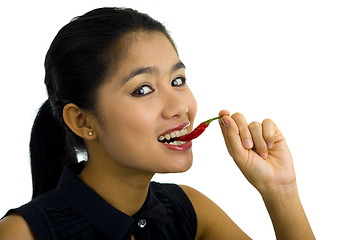 Image showing woman eating a hot chili pepper
