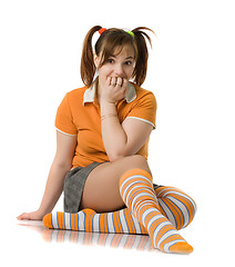 Image showing Adult girl with a two pony-tail sits on a floor