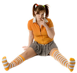 Image showing Adult girl with a two pony-tail sits on a floor