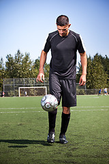 Image showing Hispanic soccer or football player kicking a ball