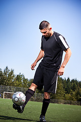 Image showing Hispanic soccer or football player kicking a ball